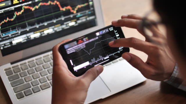 A Man Analyzing Looking Stock Market on Smart phone