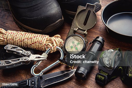 istock Outdoor travel equipment planning for a mountain trekking camping trip on wooden background 1156470896