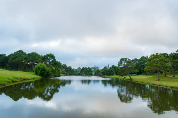 istock Background with beautiful green meadow with dramatic sky and clouds reflection on the lake 1156472765