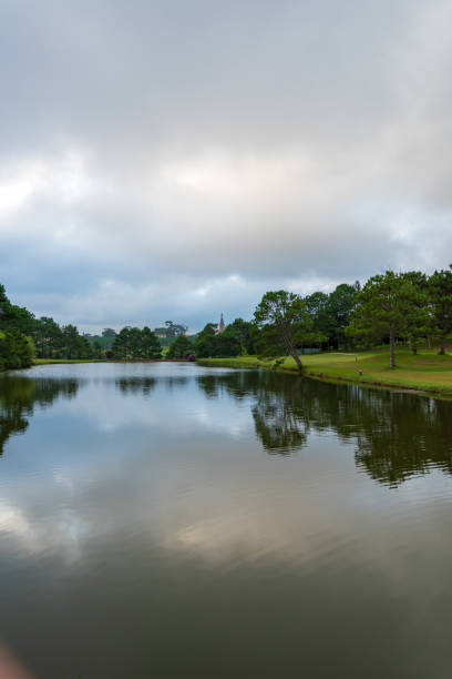 istock Background with beautiful green meadow with dramatic sky and clouds reflection on the lake 1156473280