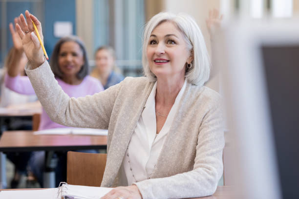istock Diverse group of female students raise hands in class 1156473575