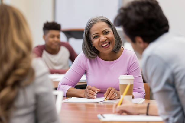 istock Diverse adult classmates finish homework assignment 1156473620