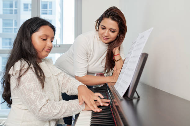 istock Teacher with student playing the piano 1156474315