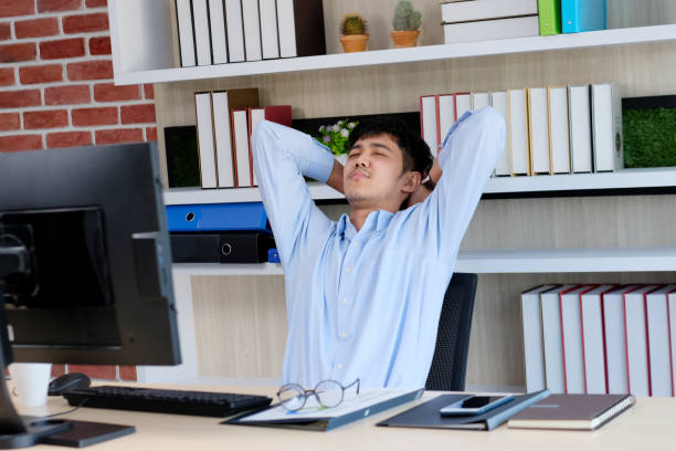 istock Young asian office man stretching body for relaxing while working with computer at his desk, office lifestyle, business situation 1156474683