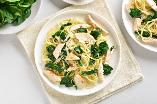 istock Spaghetti with spinach leaves, slices grilled chicken breast and grated cheese 1156475824