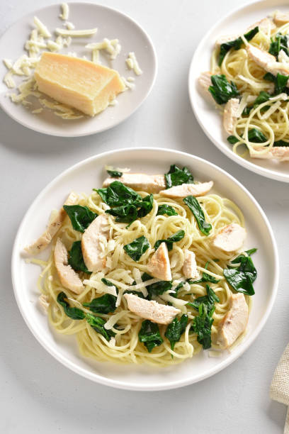 istock Spaghetti with spinach leaves, slices grilled chicken breast and grated cheese 1156475828