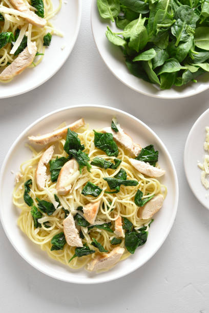 istock Spaghetti with spinach leaves, slices grilled chicken breast and grated cheese 1156475852