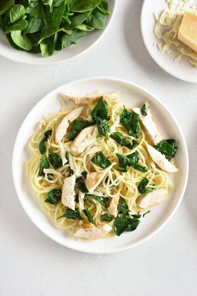 istock Spaghetti with spinach leaves, slices grilled chicken breast and grated cheese 1156475868