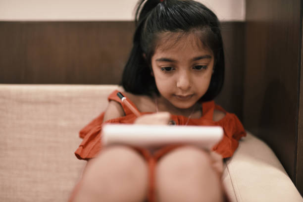 istock Preschool age girl writing at home 1156476383