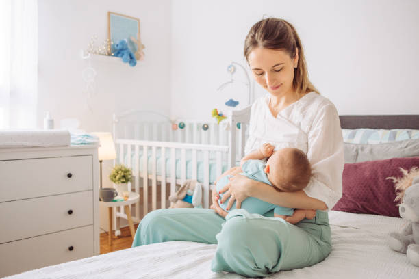 Breastfeeding mother Mother breastfeeding baby son in bedroom, they enjoy in this moment together 2 5 months stock pictures, royalty-free photos & images
