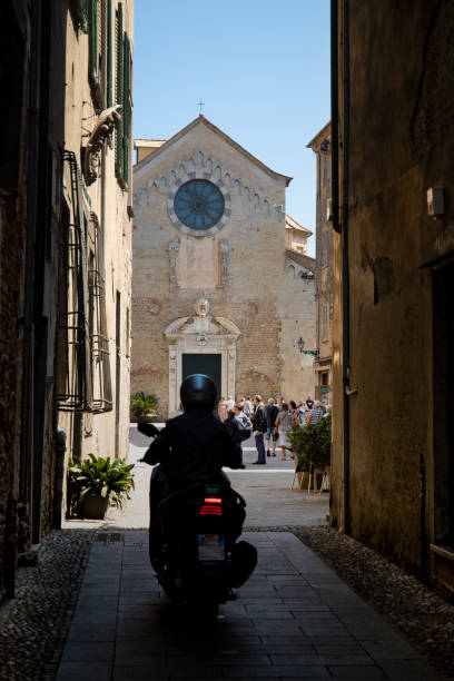 motorcycle and st michael cathedral. albenga, italy. - italy albenga liguria tower imagens e fotografias de stock