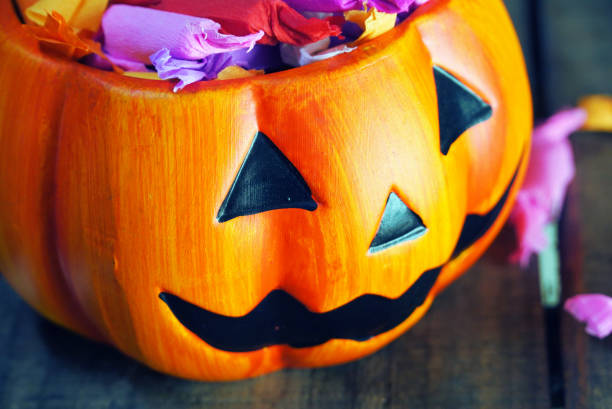 istock Close up pumpkin with candy on wood table for halloween concept. 1156479830