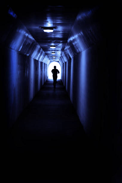 istock Man running in tunnel towards light seeking a certain destination and achievement 1156480676