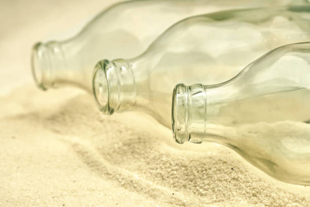 Three empty bottles glass on the beach,environment day concept.