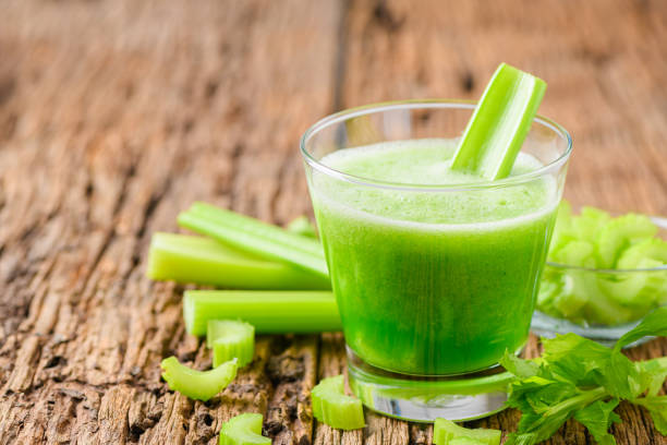 jugo de apio verde fresco en vidrio - celery fotografías e imágenes de stock