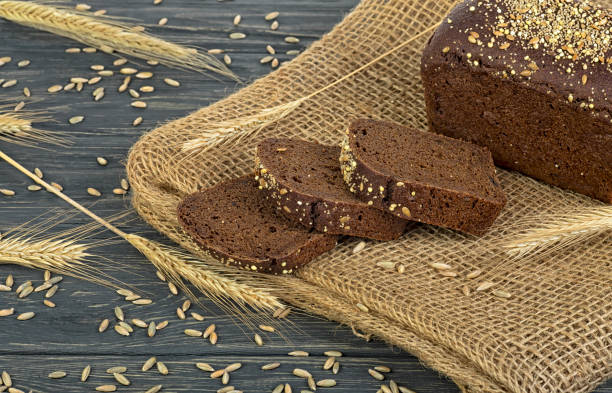 istock Rye bread and ears of rye on wooden table 1156481002