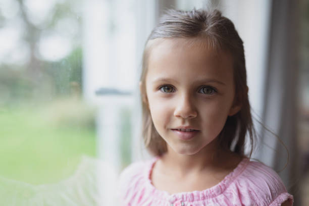 istock Girl looking near window at home 1156482108