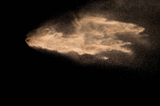 istock Abstract sand cloud. Golden colored sand splash agianst dark background. 1156484619