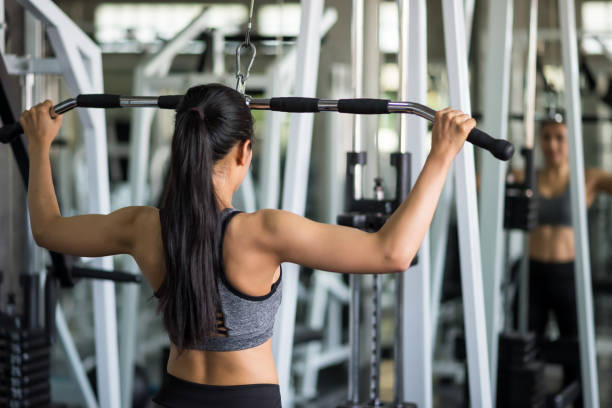 istock Woman pumping back muscles in gym 1156484780
