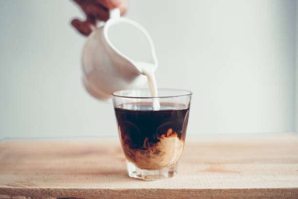 istock cold brew coffee Black coffee in a glass, add milk 1156484994
