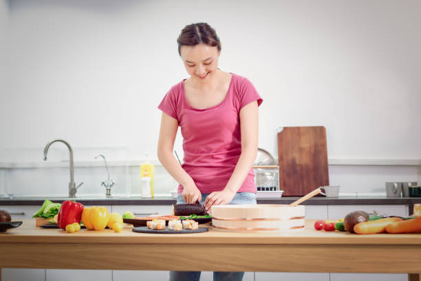 woman preparing sushi in domestic kitchen - sushi japanese culture food domestic kitchen imagens e fotografias de stock