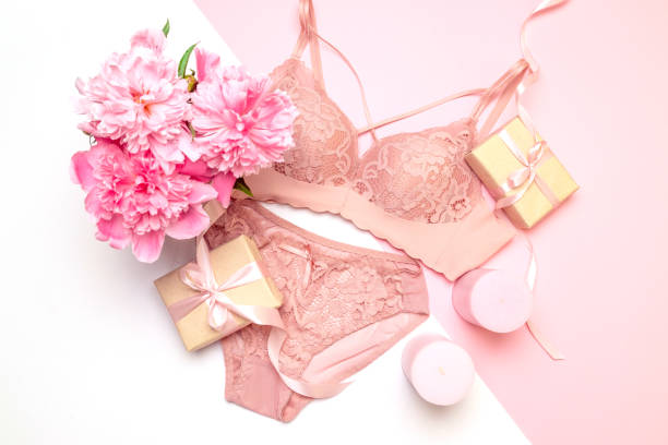 female elegant pink lace bra and panties, flowers pink candles, a bouquet of beautiful peonies top view - panties lingerie sensuality bra imagens e fotografias de stock