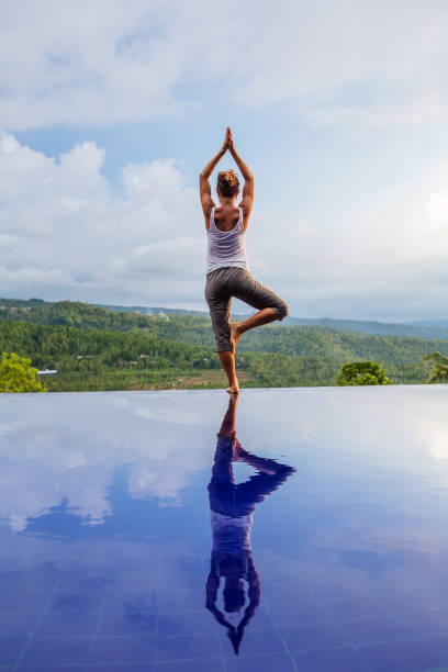 istock Caucasian woman practicing yoga by the pool 1156492293