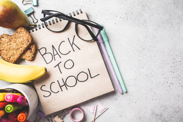 istock Back to school concept.  Notebook, glasses, pens and stationery objects on a gray background, top view. 1156493847