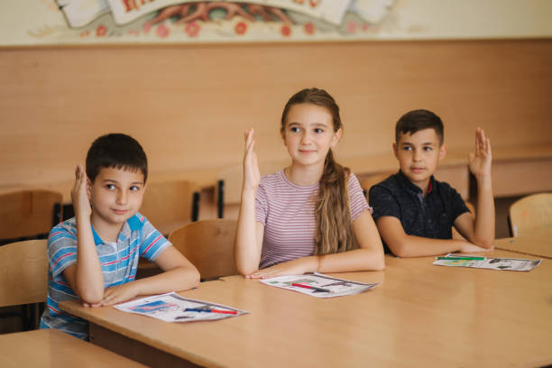 istock Group of school kids with pens and notebooks writing test in classroom. education, elementary school, learning and people concept 1156496707