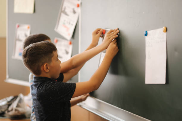 istock Children in school stand by the blackboard. Elementary school. education 1156499230