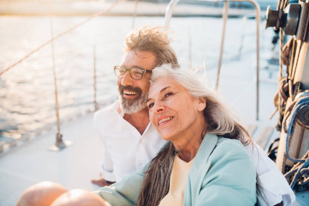 Mature couple smiling Senior couple in love sailing together old boat stock pictures, royalty-free photos & images