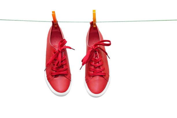 istock Red sneakers hang on clothespins on a rope. Close-up. 1156501795