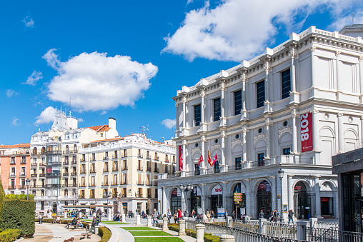 People walking next to the Teatro Real (Royal Theatre) in the Plaza de Oriente square at downtown Madrid city, Spain.