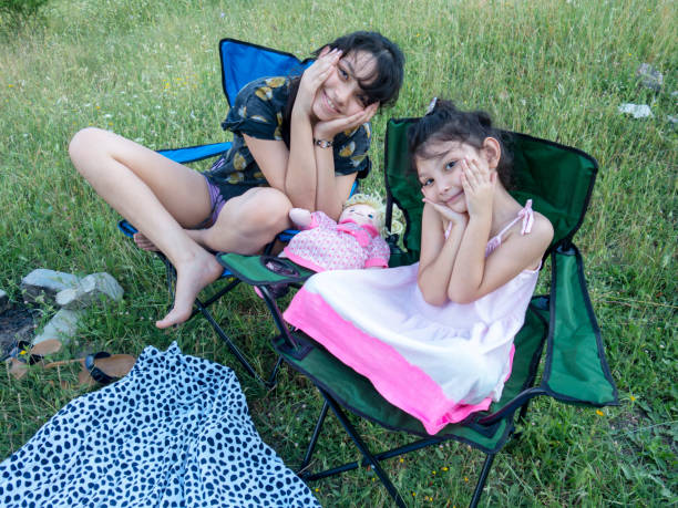 istock Two cute girls sitting on chair 1156502555