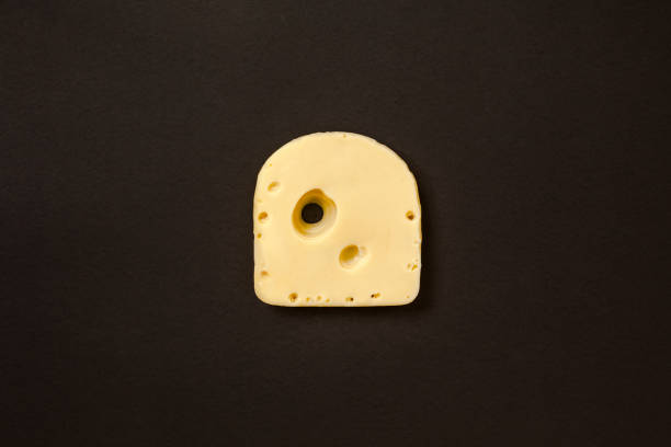 istock Piece of cheese on black background 1156503488