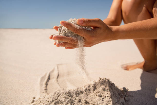 istock Woman playing with sand on the beach 1156506194