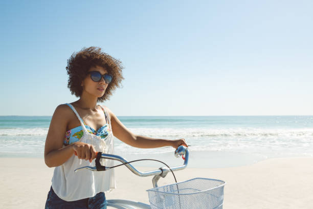 istock Woman walking with bicycle on the beach 1156507079