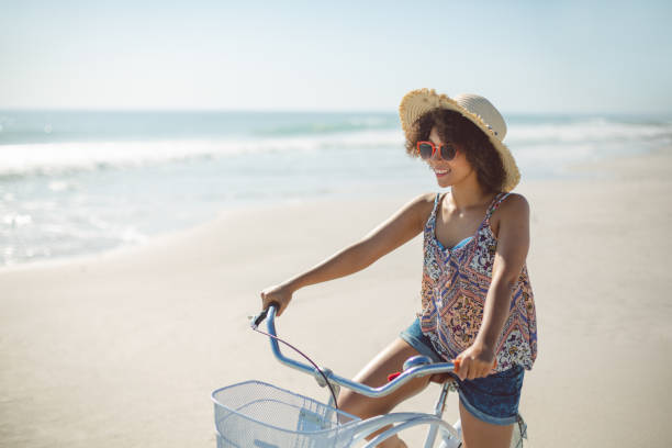 istock Woman with bicycle at beach on a sunny day 1156508123