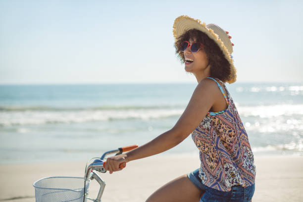 istock Woman riding a bicycle at beach on a sunny day 1156508259