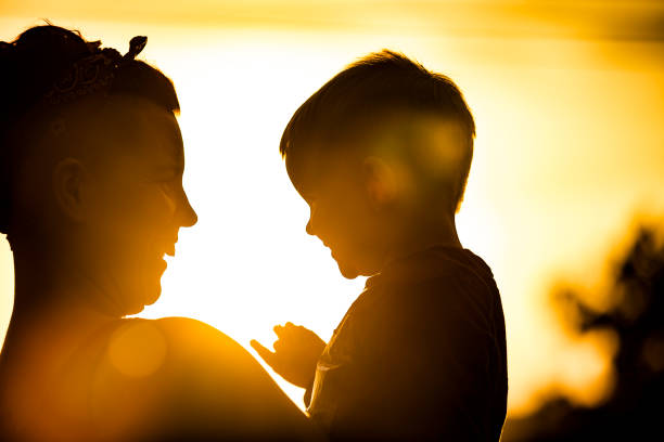 istock Smiling Mother and Son Enjoying Outdoors During Sunset 1156509963