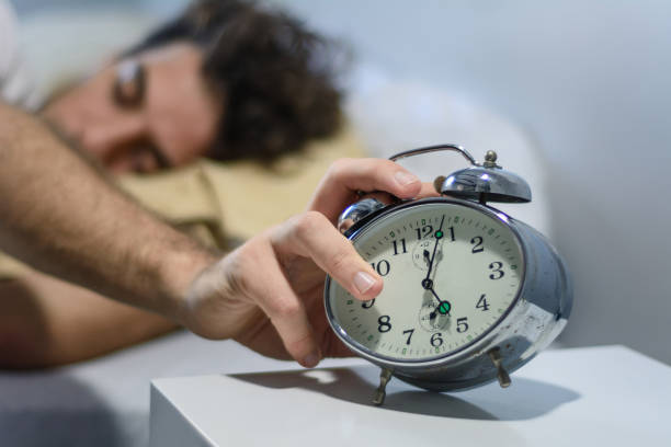 istock Frustrated young man woken-up by his alarm clock 1156510118