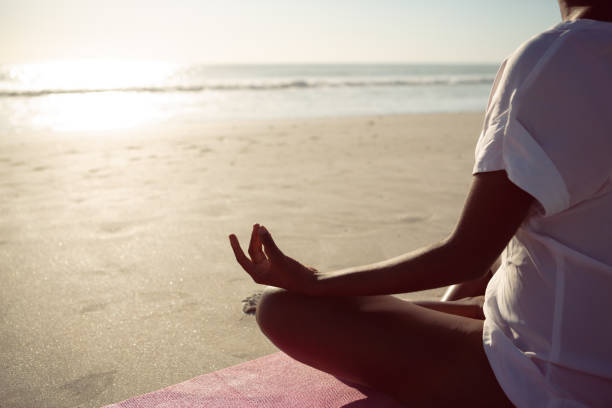 istock Woman performing yoga on the beach 1156511056