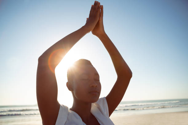istock Woman performing yoga on the beach 1156511157