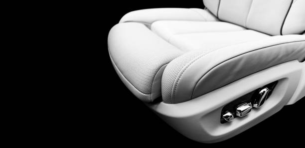 istock White leather interior of a car. Perforated white leather comfortable seats with stitching isolated on black background. Car interior details. Car detailing. Car inside. Black and white 1156512328