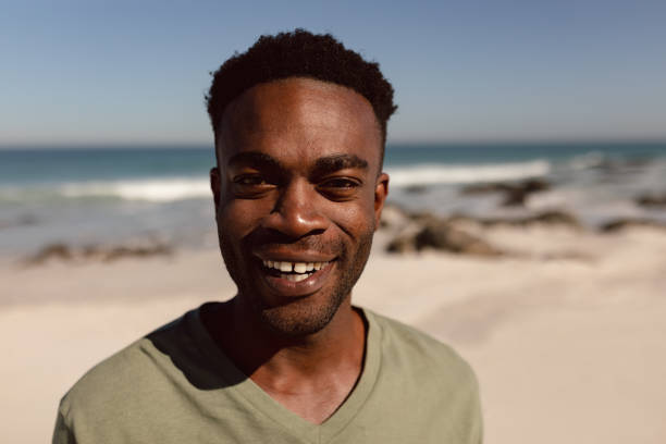 istock Man looking at camera on beach in the sunshine 1156512693
