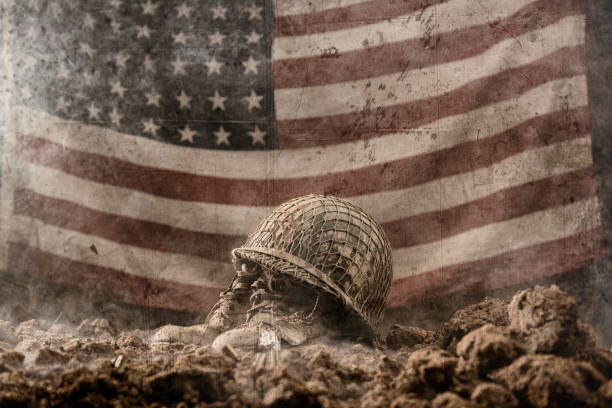 Battlefield memorial for fallen soldier with 48 star US flag A muddy army helmet sitting atop a pair of empty army boots with a pair of dog tags as a memorial to a fallen soldier in battle with a 48 star US flag hanging in the background. This could be from World War II or the Korean war. vintage american flag stock pictures, royalty-free photos & images