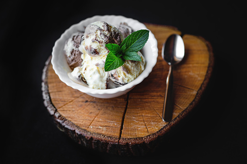 Beautiful and tasty decorated with mint ice cream and a spoon on a wooden log.