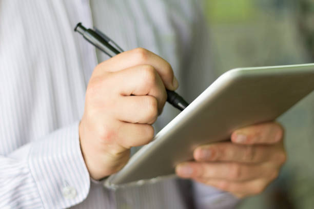 istock young man holding a digital tablet, close-up 1156515729