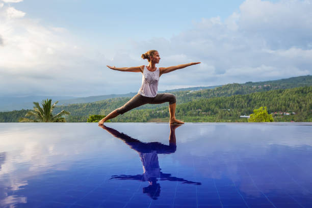 istock Caucasian woman practicing yoga by the pool 1156519567