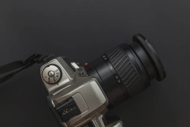 istock Photographer workplace with dslr camera system on dark black table background. Hobby travel photography concept 1156519682